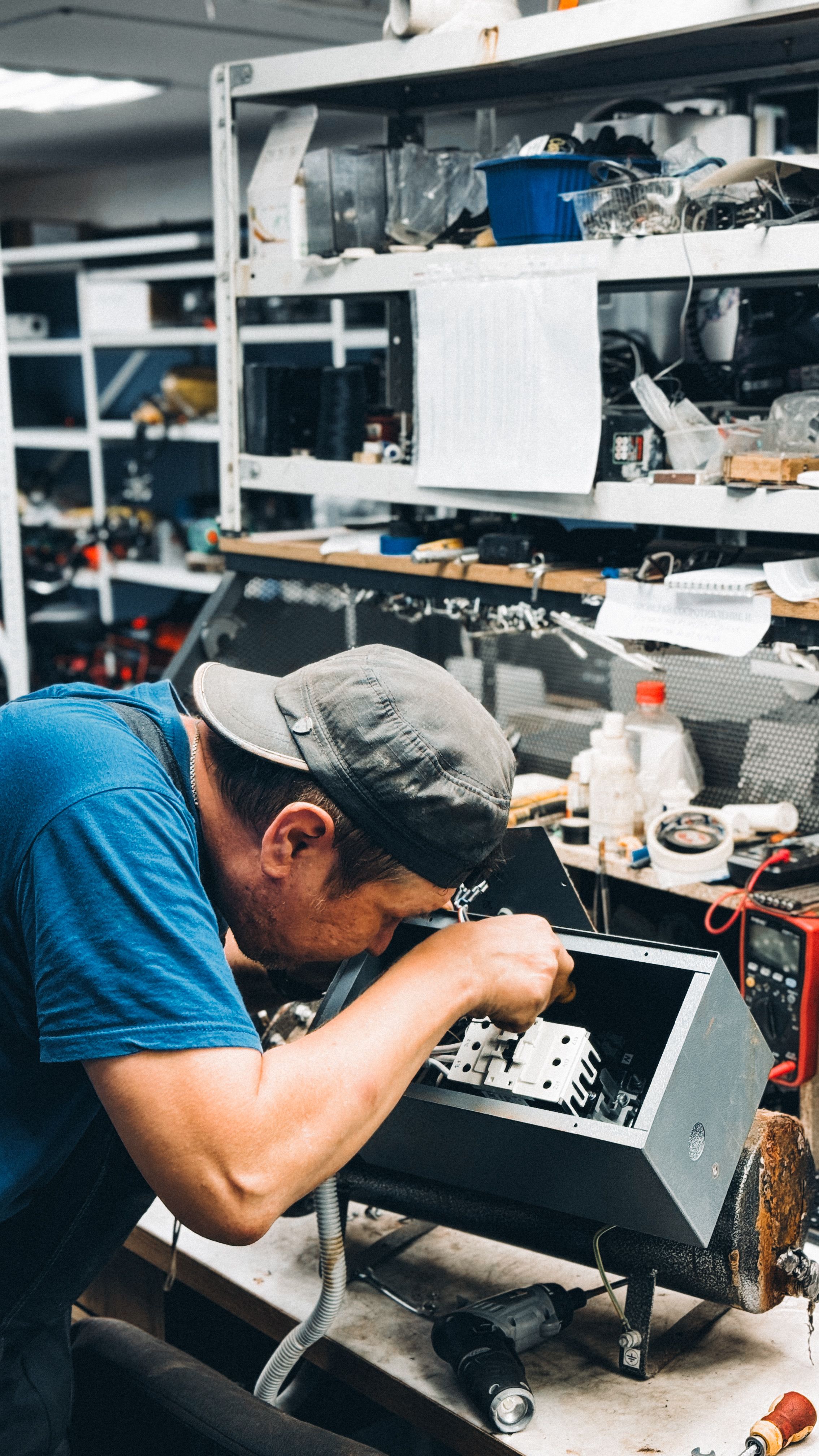 Professional electrician working on electrical panel with safety equipment